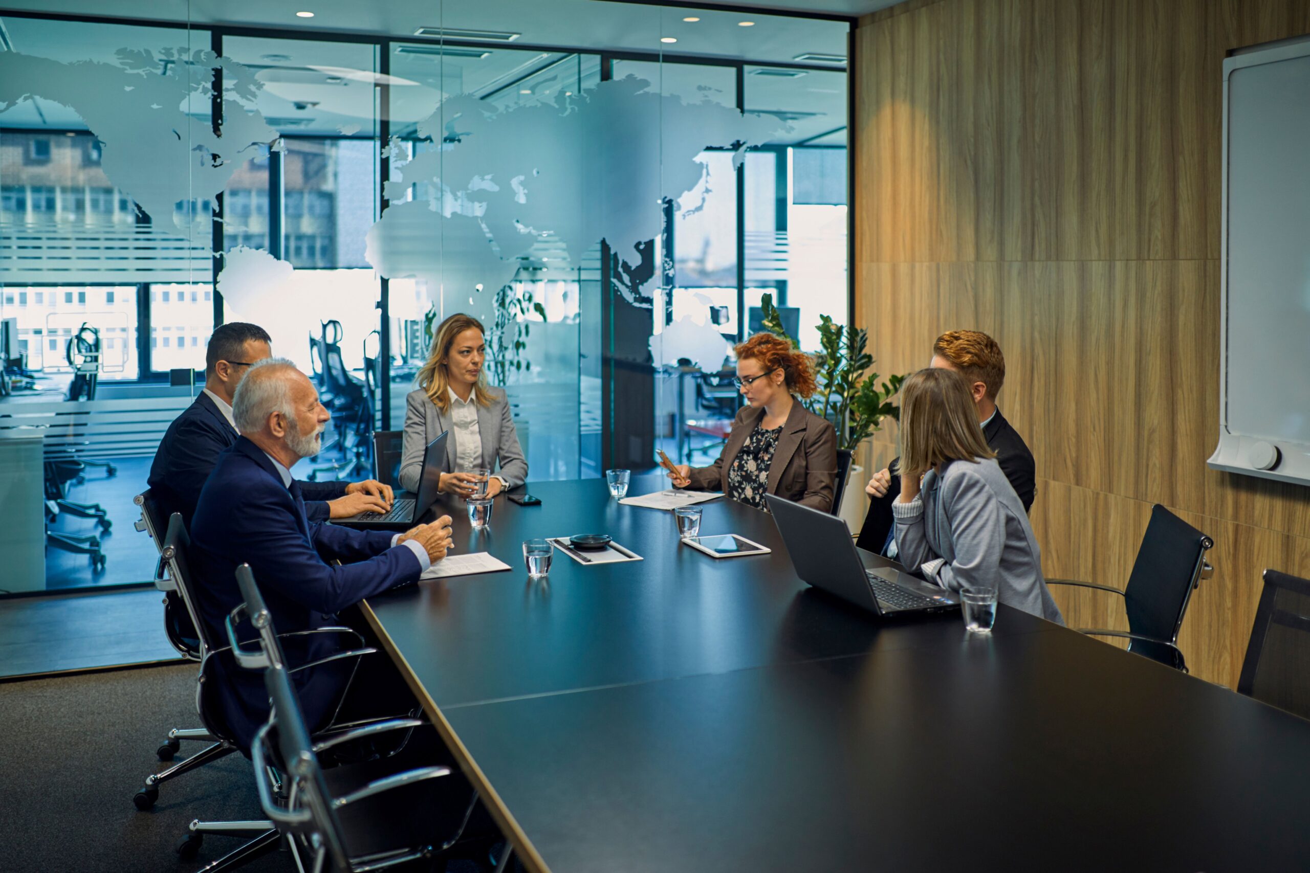 Mehrere Personen besprechen sich in einem Meeting ob und wie sich die Implementierung eines  modernen Systems lohnen würde 